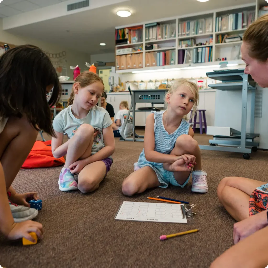 Children gathered with teacher on the floor