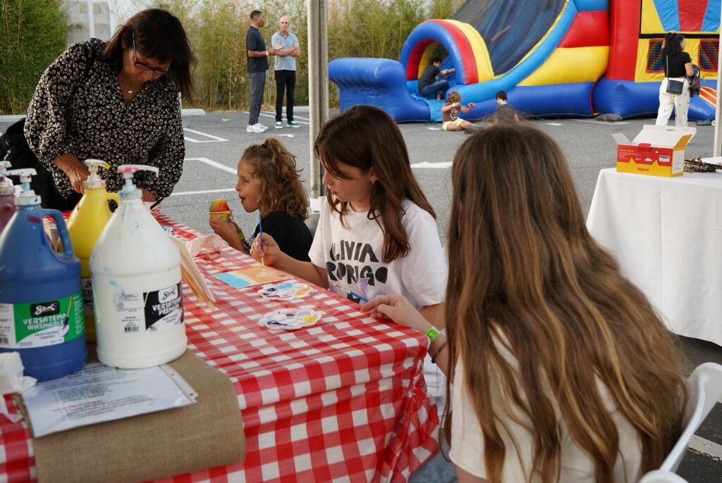 group of girls painting at a picnic table
