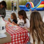 group of girls painting at a picnic table
