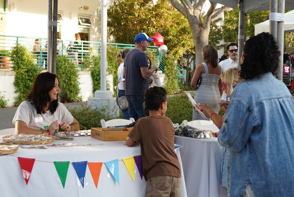 families checking out vendor tables at event