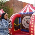mom smiling outside a bounce house